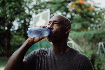 Man drinkt een flesje water voor de dorst.